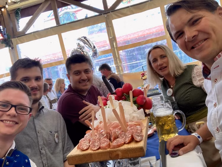 Mehrere Personen an einem Biertisch vor einer Brotzeit