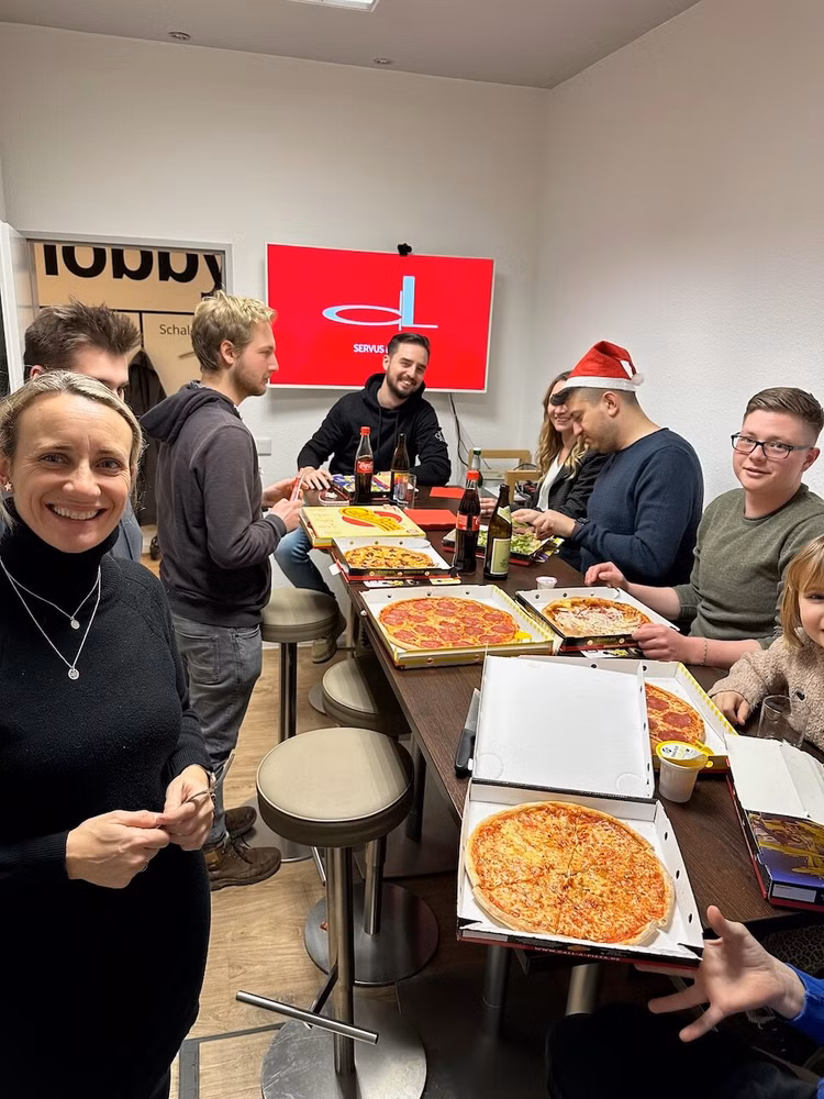 Mehrere Personen essen gemeinsam Pizza